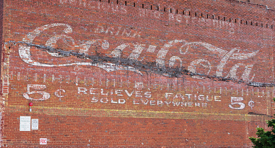 Johnson City, TN, USA-9/30/18: An old coca-cola sign on the side of an old brick building, advising that it 