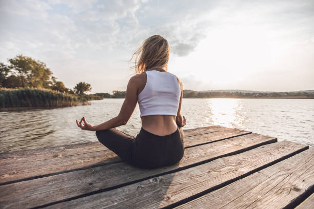 istock Girl meditating on pier 1052876184