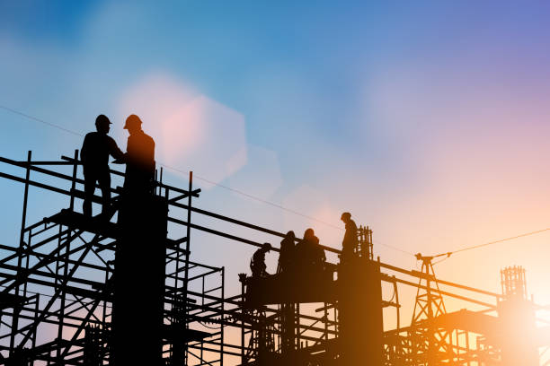 istock Silhouette of engineer and construction team working at site over blurred background for industry background with Light fair.Create from multiple reference images together 1052879968
