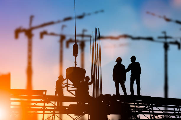 istock Silhouette of engineer and construction team working at site over blurred background for industry background with Light fair.Create from multiple reference images together 1052879970