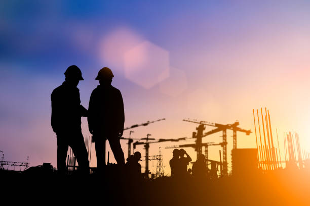 istock Silhouette of engineer and construction team working at site over blurred background for industry background with Light fair.Create from multiple reference images together 1052879972