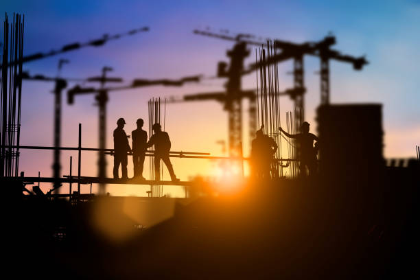 istock Silhouette of engineer and construction team working at site over blurred background for industry background with Light fair.Create from multiple reference images together 1052879974