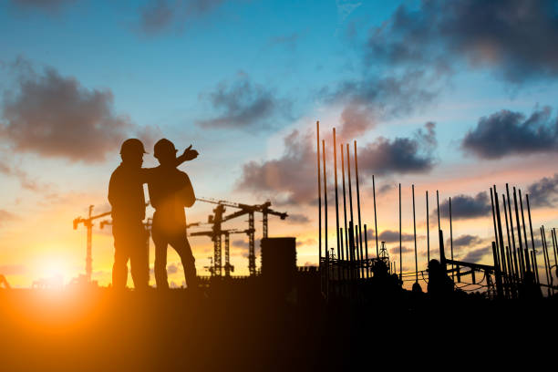 istock Silhouette of engineer and construction team working at site over blurred background for industry background with Light fair.Create from multiple reference images together 1052879976