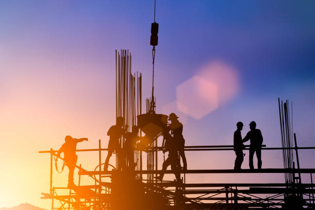 istock Silhouette of engineer and construction team working at site over blurred background for industry background with Light fair.Create from multiple reference images together 1052879982