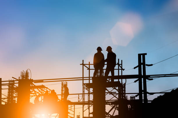 istock Silhouette of engineer and construction team working at site over blurred background for industry background with Light fair.Create from multiple reference images together 1052879984