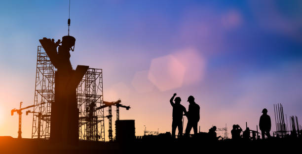 istock Silhouette of engineer and construction team working at site over blurred background for industry background with Light fair.Create from multiple reference images together 1052879986
