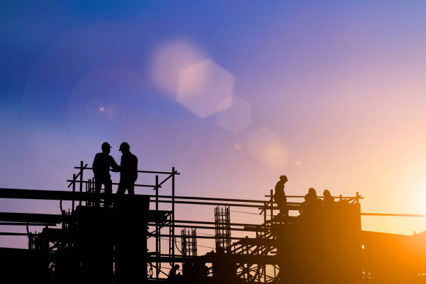 istock Silhouette of engineer and construction team working at site over blurred background for industry background with Light fair.Create from multiple reference images together 1052879992