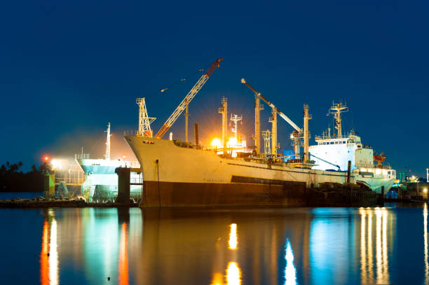 istock Cargo ship under repair in floating dry dock at night 1052881478