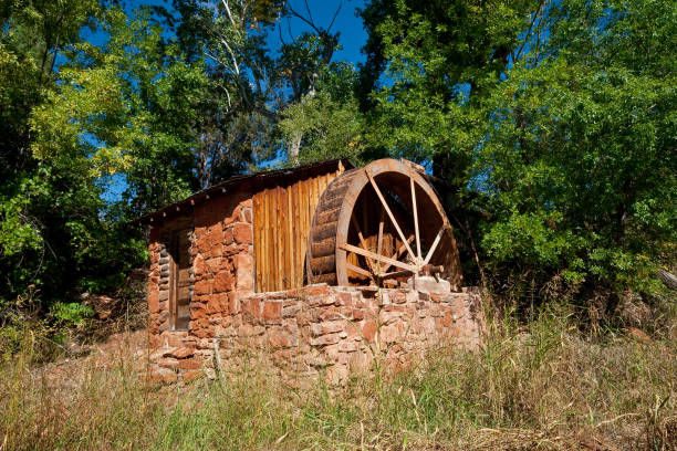 Historic Power Generating Water Wheel In the 1930's the owners of Crescent Moon Ranch installed a water wheel in their irrigation ditch. Falling water spun the wheel, driving a water pump and an electric generator. This system pumped water to storage tanks and brough power to the ranch. Crescent Moon Ranch is in the Coconino National Forest near Sedona, Arizona, USA. jeff goulden environmental conservation stock pictures, royalty-free photos & images