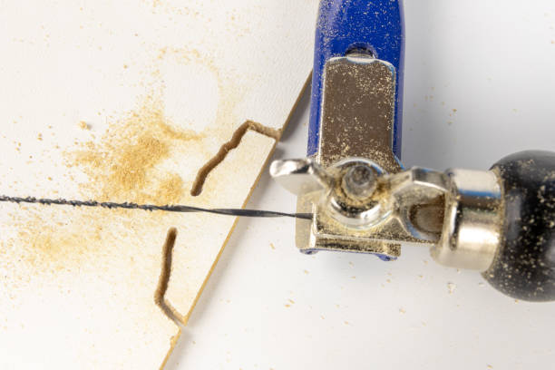 istock Precise saw for modelers and carpenters on the workshop table. Saw with a small blade for cutting complicated shapes. White background. 1052894264