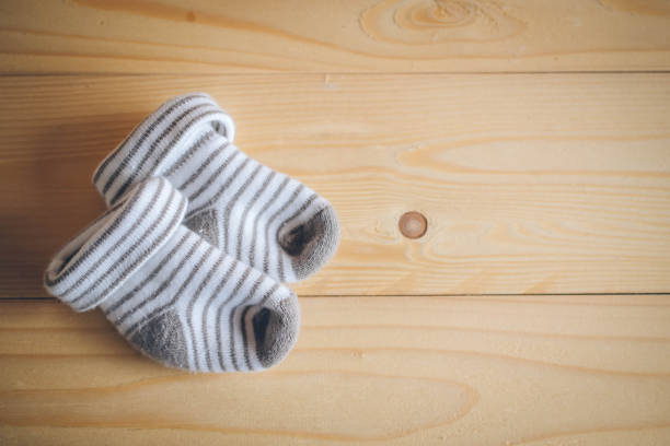 istock Baby socks  on wooden background 1052906282