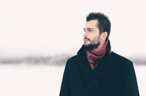 istock Winter portrait bearded elegant man looks aside on snowy background 1052911800