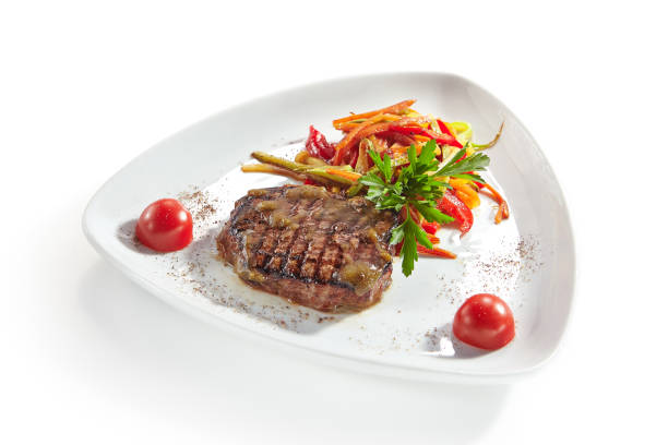 istock Grilled Beef Steak with Vegetables Isolated on White Background 1052912542