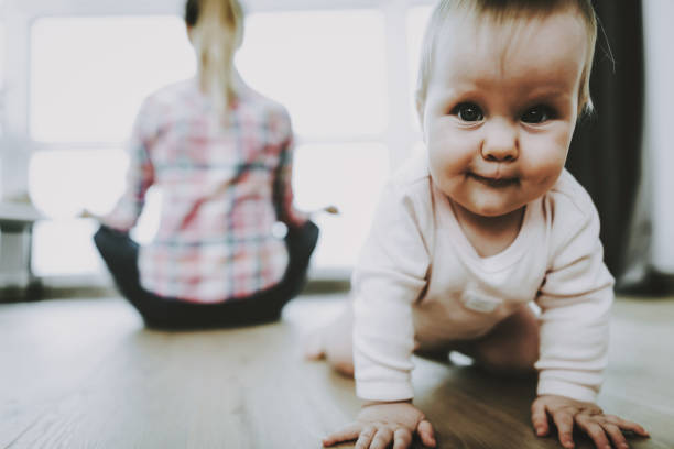 istock Cute Smiling Baby Crawls and Mother Sitting Back 1052914624