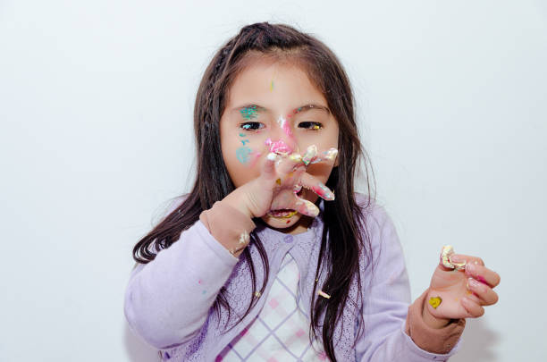 Cute little girl smeared with cake on her face for her birthday