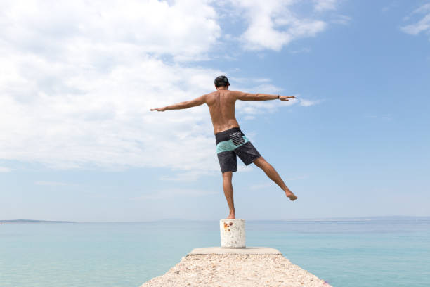 istock Man balancing on one leg next to the sea 1052918300