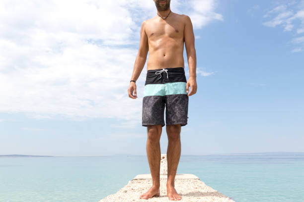 istock Man in board shorts walking towards camera 1052918352
