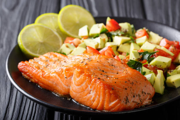 istock Freshly cooked salmon steak with lime, avocado and tomatoes close-up. horizontal 1052919878