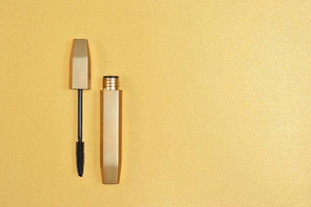 istock Single shiny black mascara for makeup on golden background 1052922570