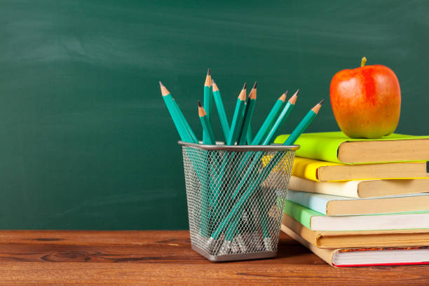 istock back to school - apple and books with pencils and blackboard 1052932772
