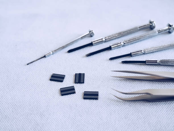 istock tweezers with screwdriver and IC on white background 1052937774