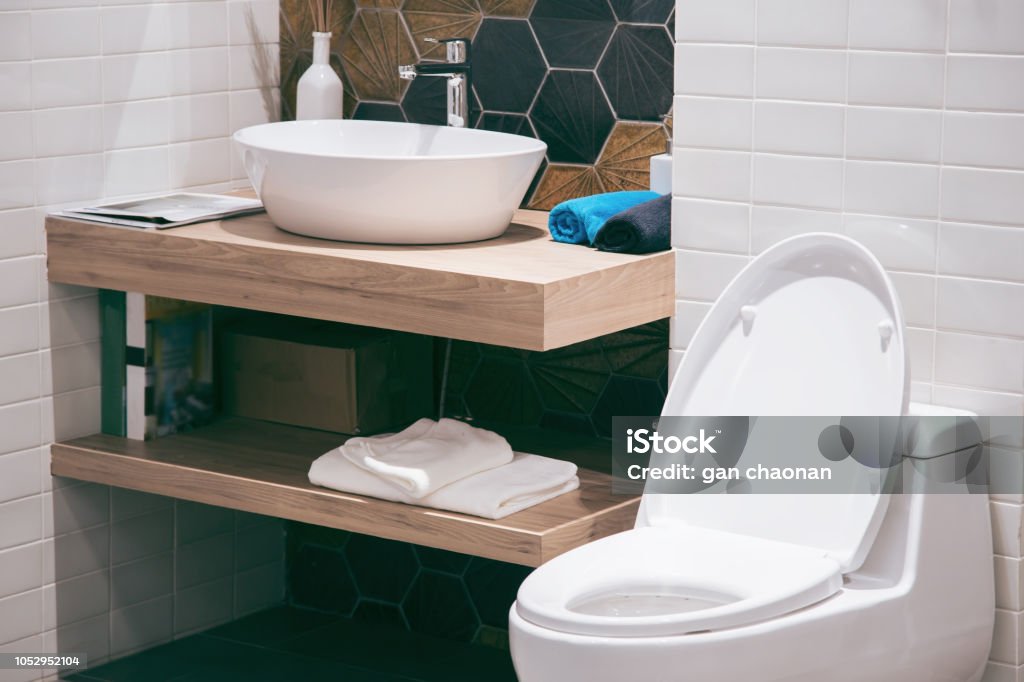 Modern spacious bathroom with bright tiles with toilet and sink. Side view Toilet Stock Photo