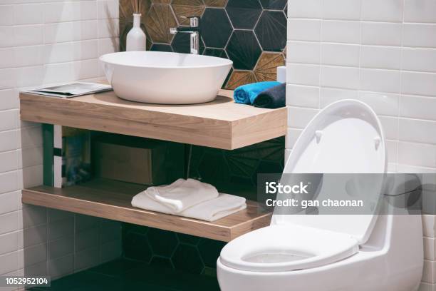 Modern Spacious Bathroom With Bright Tiles With Toilet And Sink Side View Stock Photo - Download Image Now