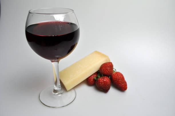 istock glass of wine on a white background with fruit and cheese 1052961448