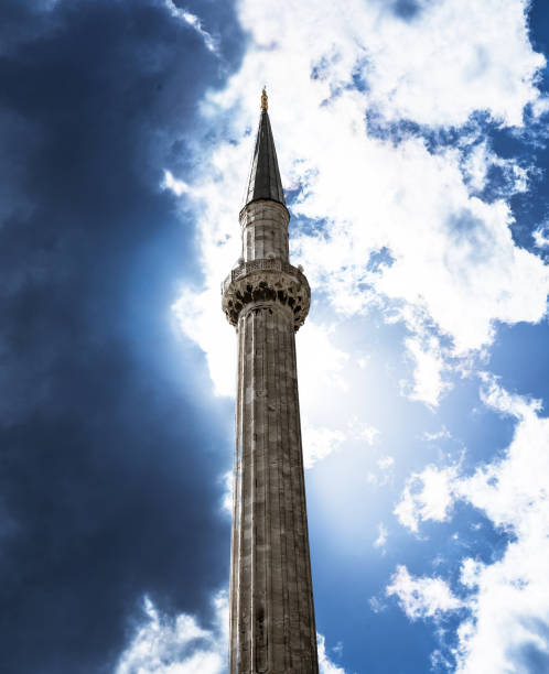 minaret d’une mosquée islamique photographié par en dessous sur un ciel dramatique avec les nuages. - gods rays audio photos et images de collection