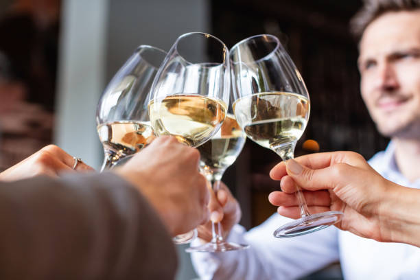 istock Four white wine glasses in a toast 1052967518