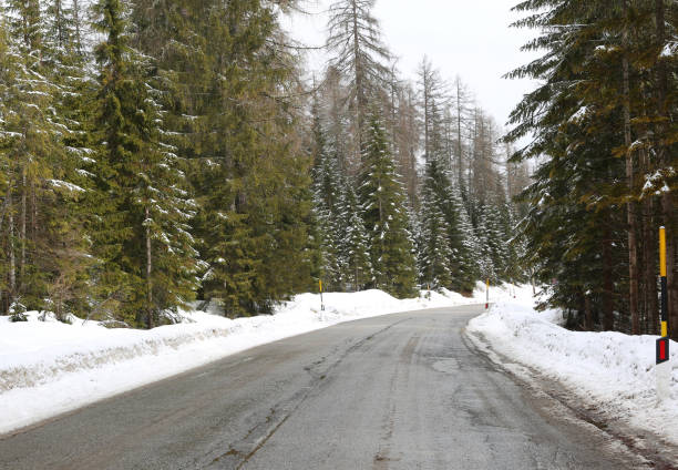 istock mountain road with snow at the edges 1052967600