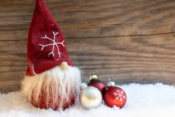 red santa claus, snow, wooden wall and christmas bells