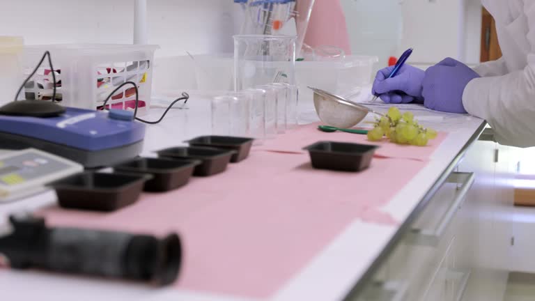 Biologist Writing Down Grape Experiment Results