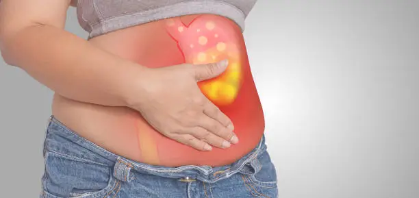 Photo of Acid reflux or Heartburn, stomach is on the woman's body gray Background, anatomy concept