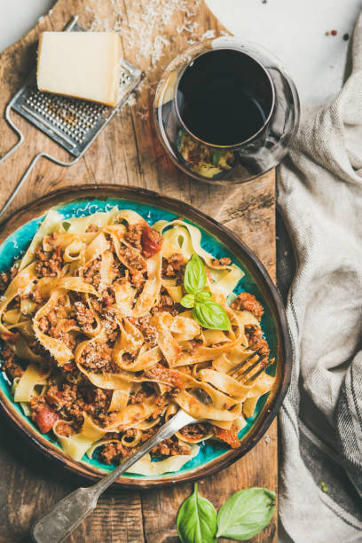 istock Pasta dinner with tagliatelle bolognese and red wine, top view 1052989270