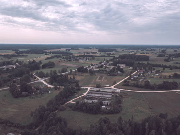 istock drone image. aerial view of rural area with fields and forests. camping housing rooftops - vintage retro look 1052990648
