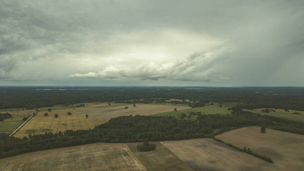 istock drone image. aerial view of rural area with fields and forests under dramatic storm clouds forming - vintage retro look 1052990874