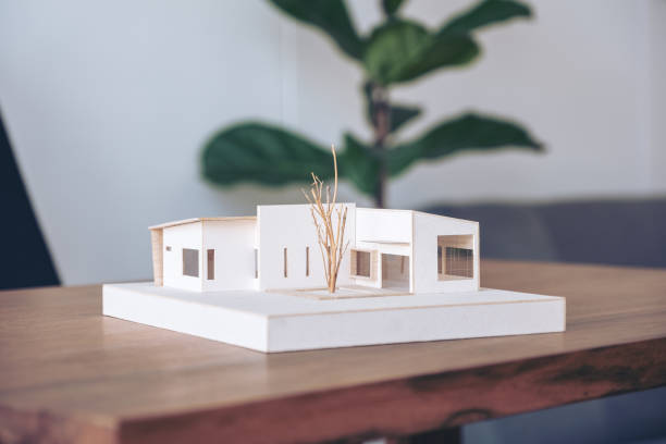 istock An architecture model on wooden table in office with blur nature background 1052993364