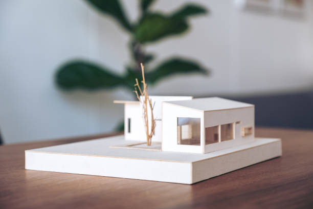 istock An architecture model on wooden table in office with blur nature background 1052993946
