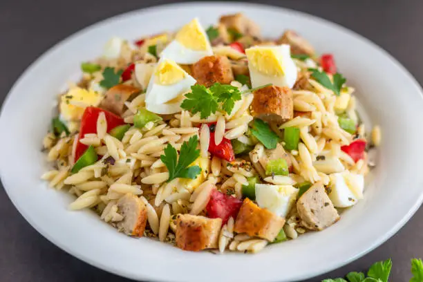 Homemade Orzo salad with chicken sausage and boiled eggs horizontal photo