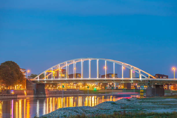 Evening view of the N344 bridge crossing the Dutch river IJssel in front of the city of Deventer Evening view of the N344 bridge crossing the river IJssel in front of the city of Deventer in Overijssel, The Netherlands deventer photos stock pictures, royalty-free photos & images