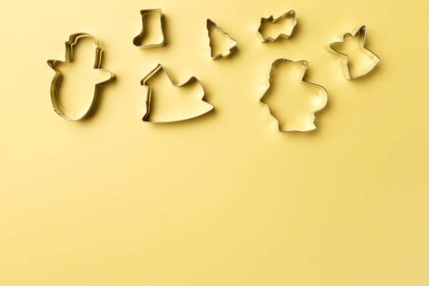 istock Christmas cookies various shape cutter on yellow background with copy space. Top view. Flat lay. Trendy colorful photo. Minimal style with colorful paper backdrop. Christmas concept 1053005262
