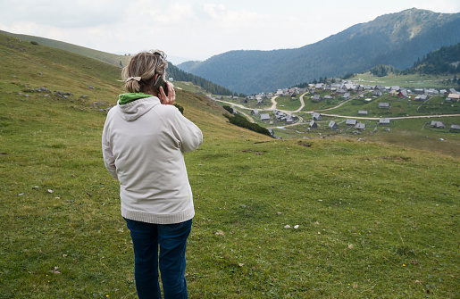 Senior woman in the mountains using her smart phone.