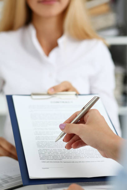 istock Female arm in white shirt offer contract form on clipboard 1053013882
