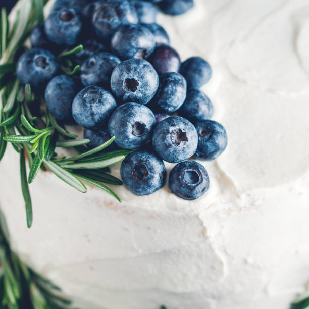 Close-up of fresh blueberries and rosemary like a decor on a cream cake.