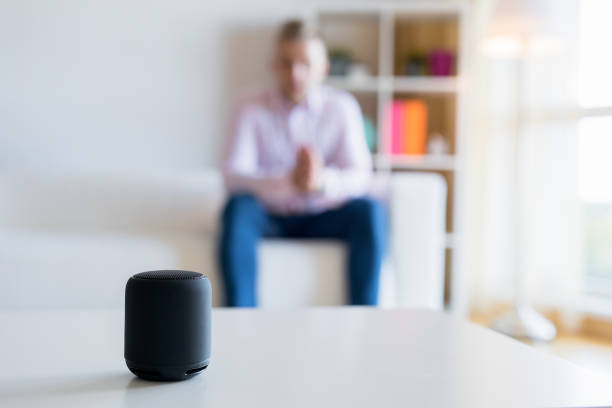 istock Man talking to virtual assistant smart speaker in living room 1053020866