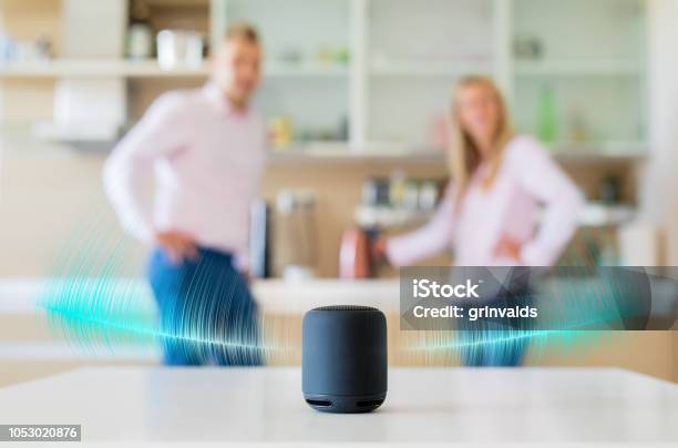 Couple Talking And Listening To Smart Speaker At Home Stock Photo - Download Image Now