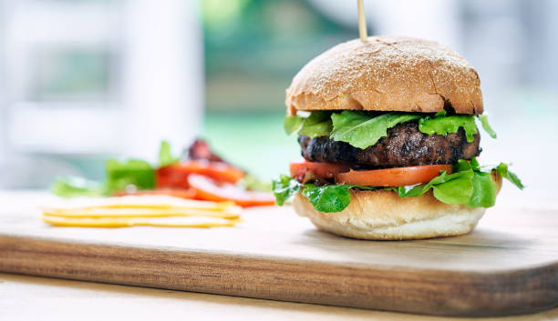 istock A beef burger in a crusty bun with lettuce and tomatoes 1053022072