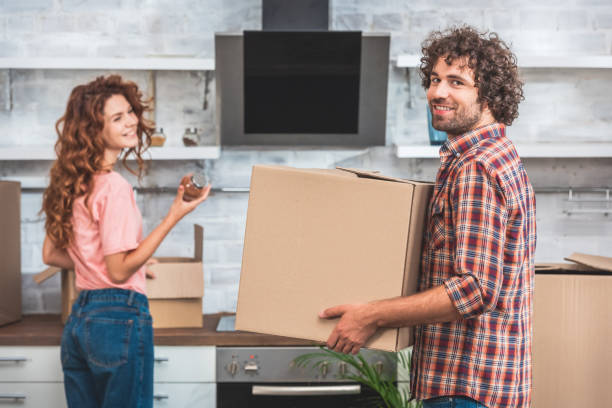 istock happy couple unpacking cardboard boxes at new home 1053024766
