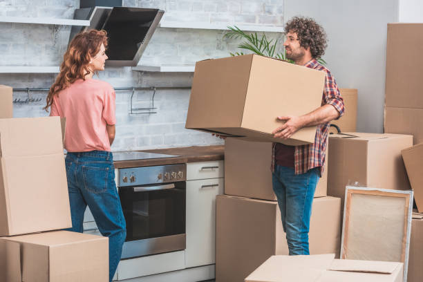 istock couple unpacking cardboard boxes together at new kitchen 1053024944